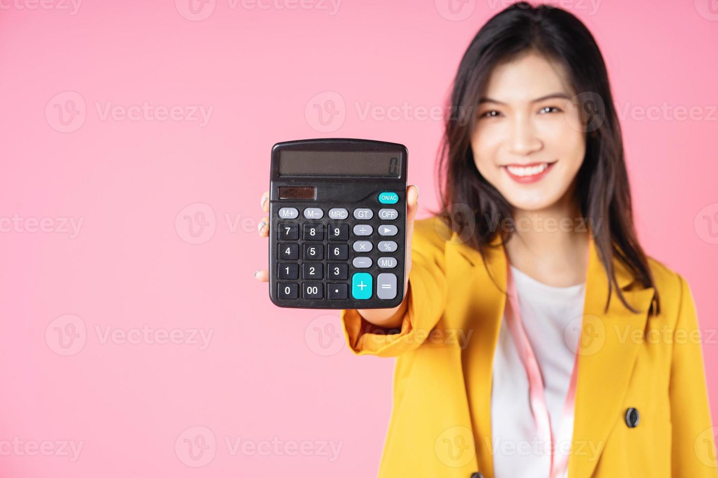 Image of young Asian businesswoman using calculator photo