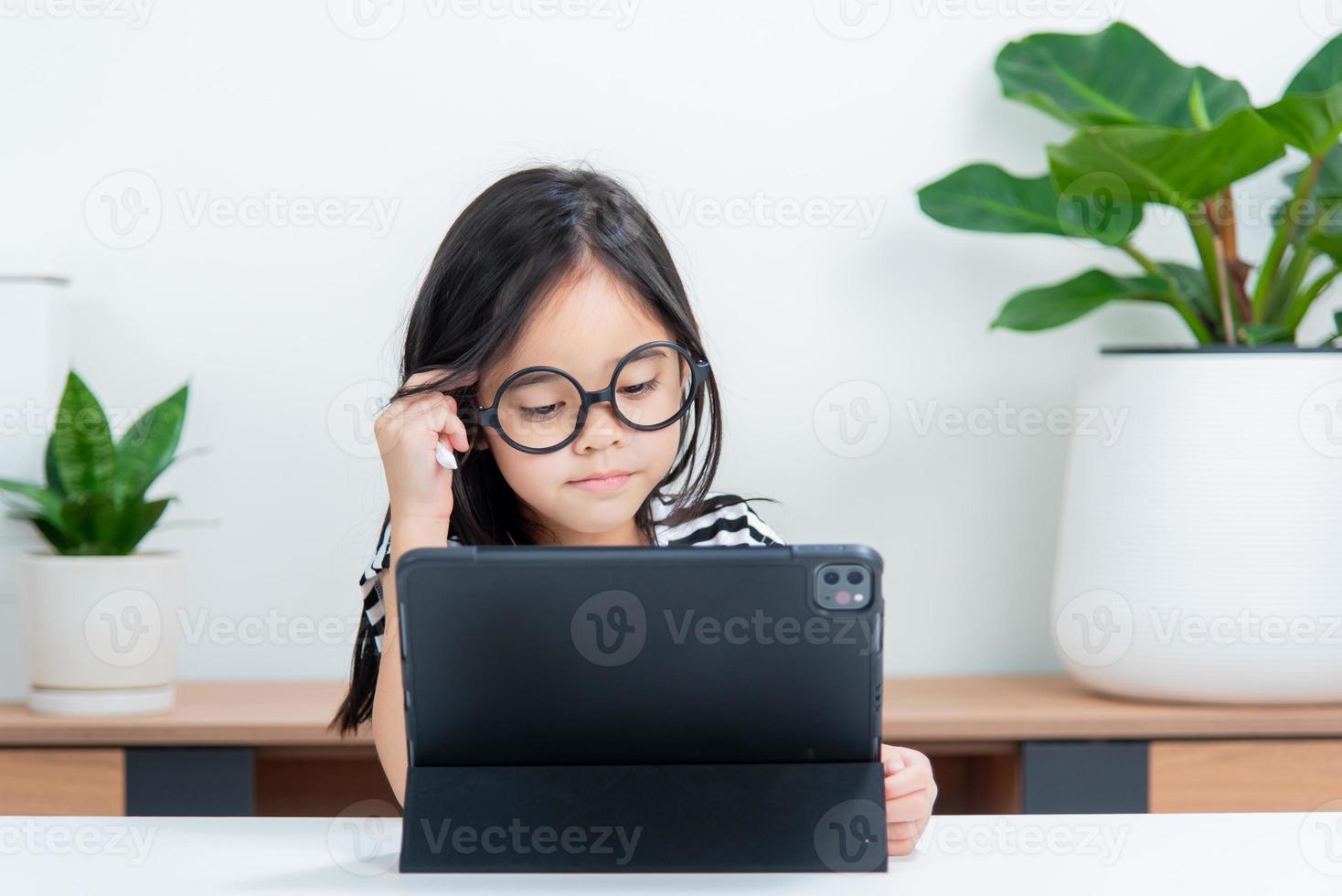 Asian child girl student wow excited on video call learning to studying online class or person learn from home school with tablet photo