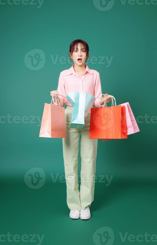 Image of young Asian girl holding shopping bag on background photo
