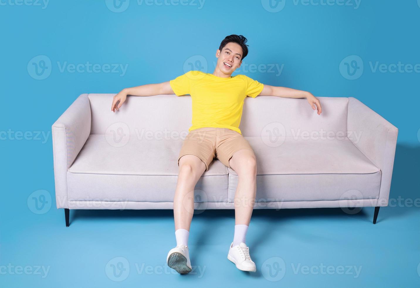 Image of young Asian man sitting on sofa photo