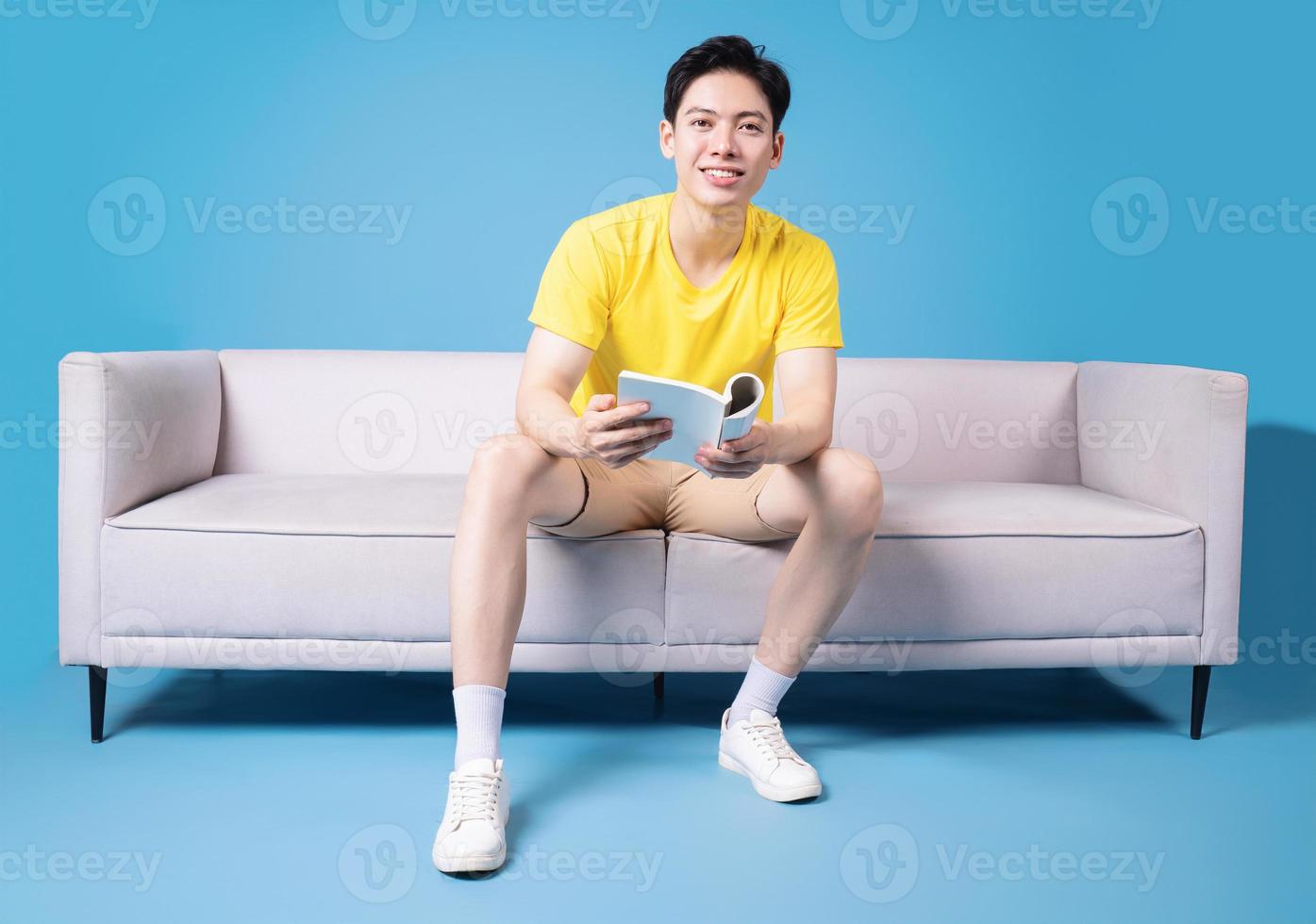 Image of young Asian man sitting on sofa photo