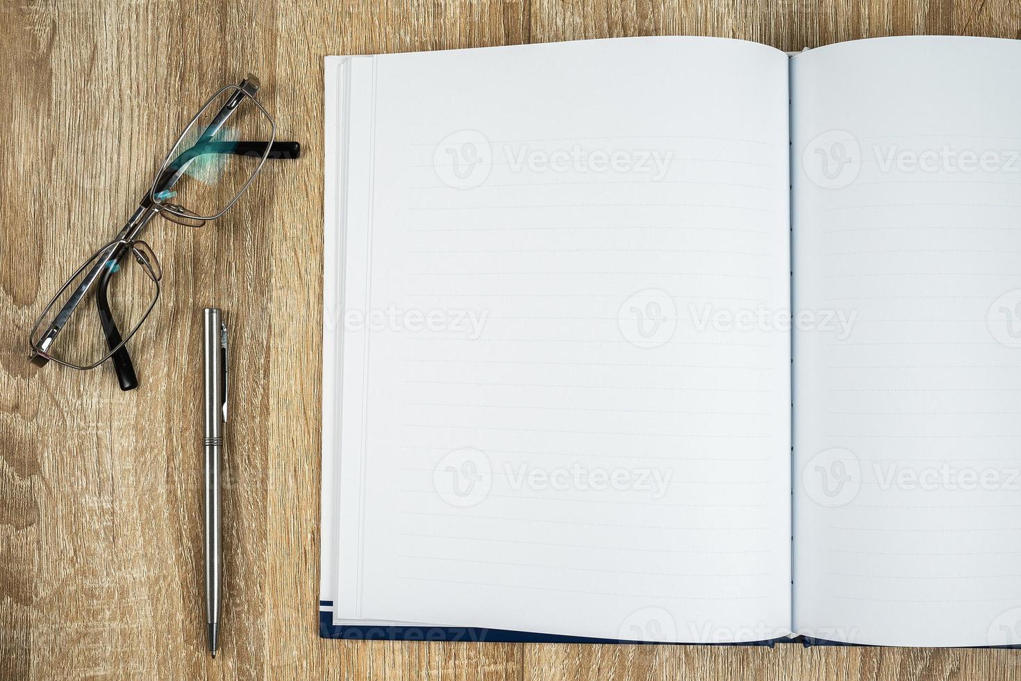 Blank notebook diary with silver pen and glasses photo