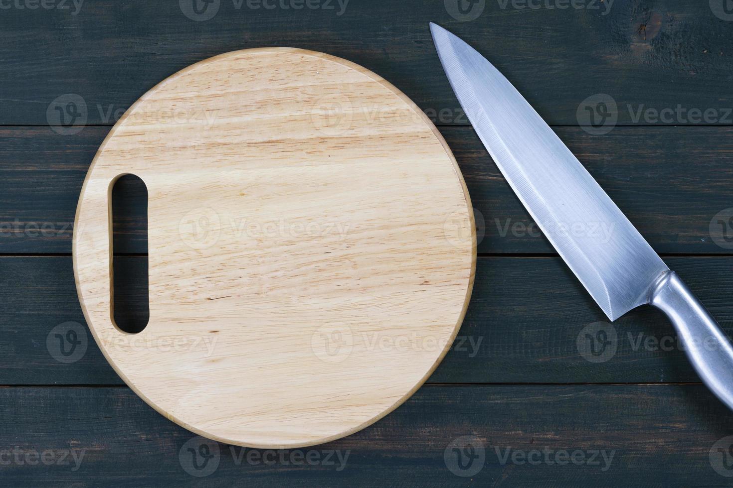 cerrar el cuchillo de cocina y la tabla de cortar redonda de madera foto