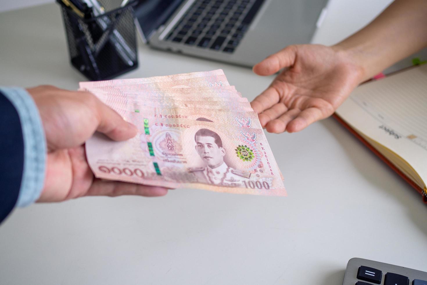 el sueldo del jefe paga a los empleados es la retribución por el trabajo realizado para la empresa. moneda tailandesa y concepto de baht tailandés foto