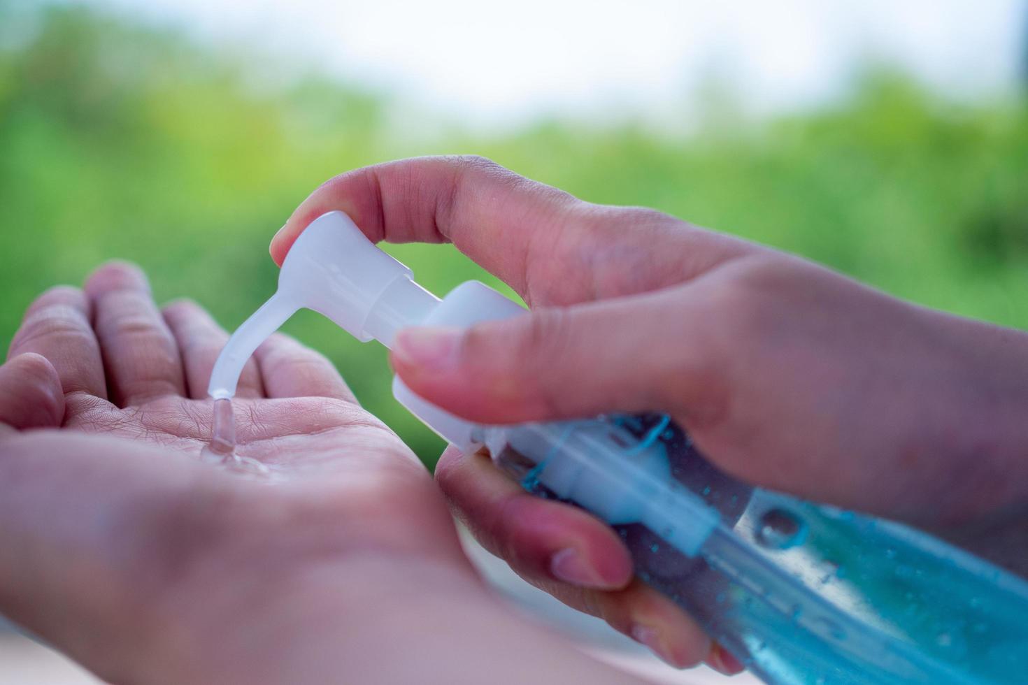 A woman s hand presses a gel to wash hands to kill viruses or bacteria or germs. Prevention of covid-19 virus spread by hand washing, rubbing with  alcohol gel photo