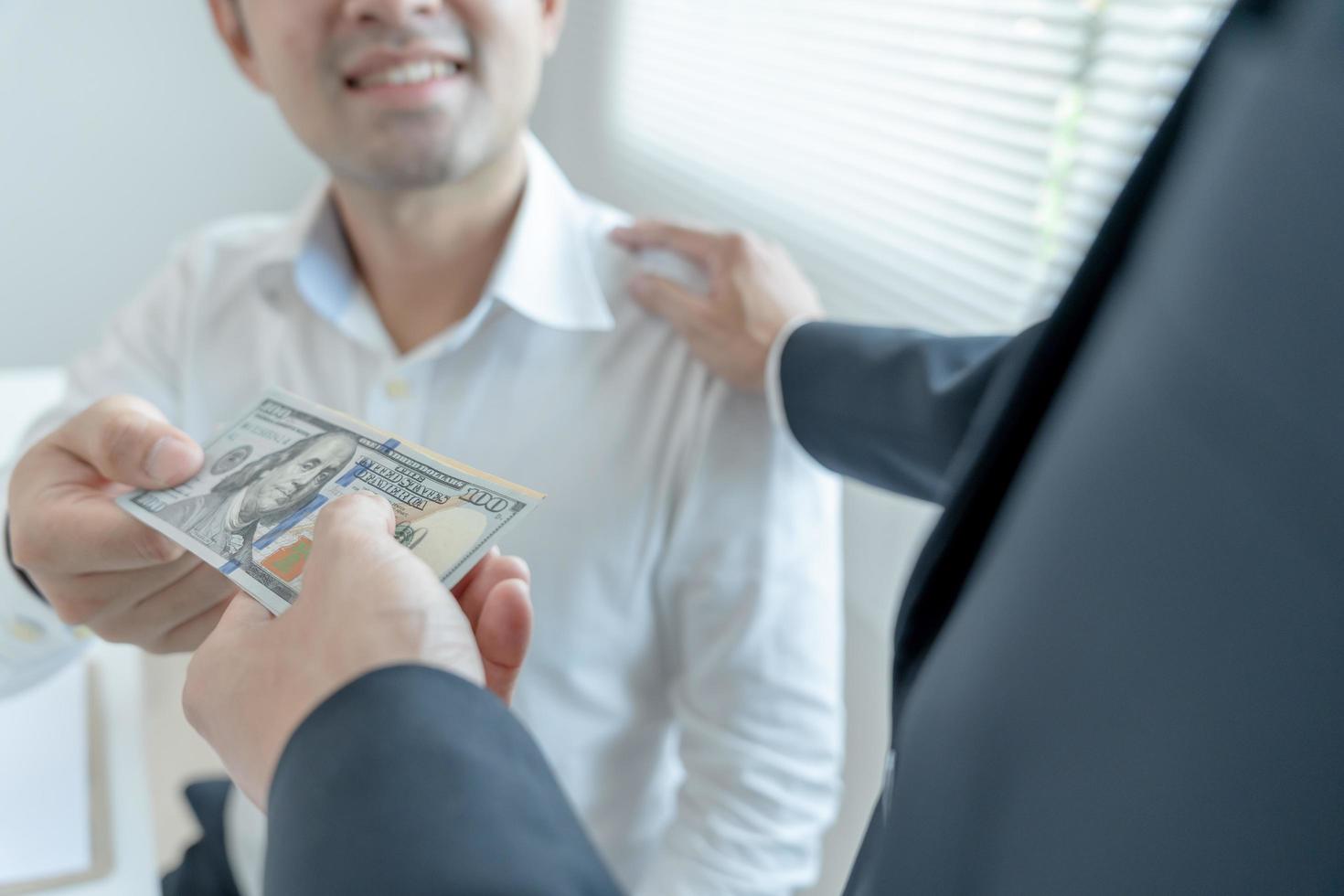 los empresarios reciben salarios o bonificaciones de la gerencia o del jefe. empresa dar recompensas para fomentar el trabajo. hombre de negocios sonriente disfrutando de una recompensa en el escritorio de la oficina. foto