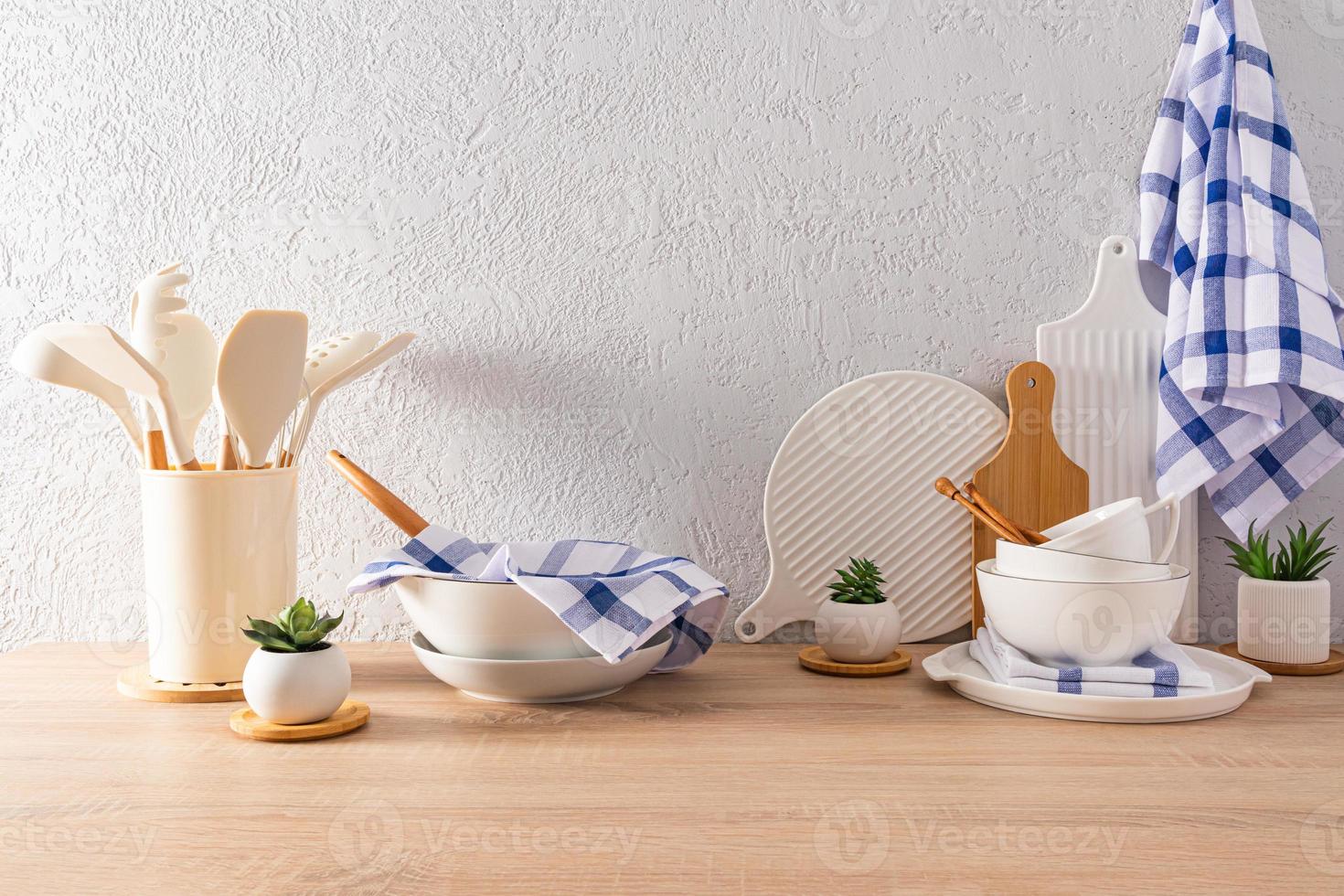 kitchen utensils, tools and utensils on a wooden countertop opposite the grey concrete wall. ecologically clean kitchen. natural materials. photo