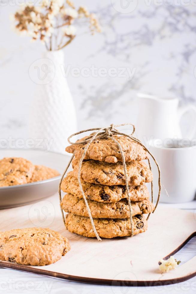 A stack of homemade oatmeal raisin cookies tied with string. Healthy baking. Vertical view photo