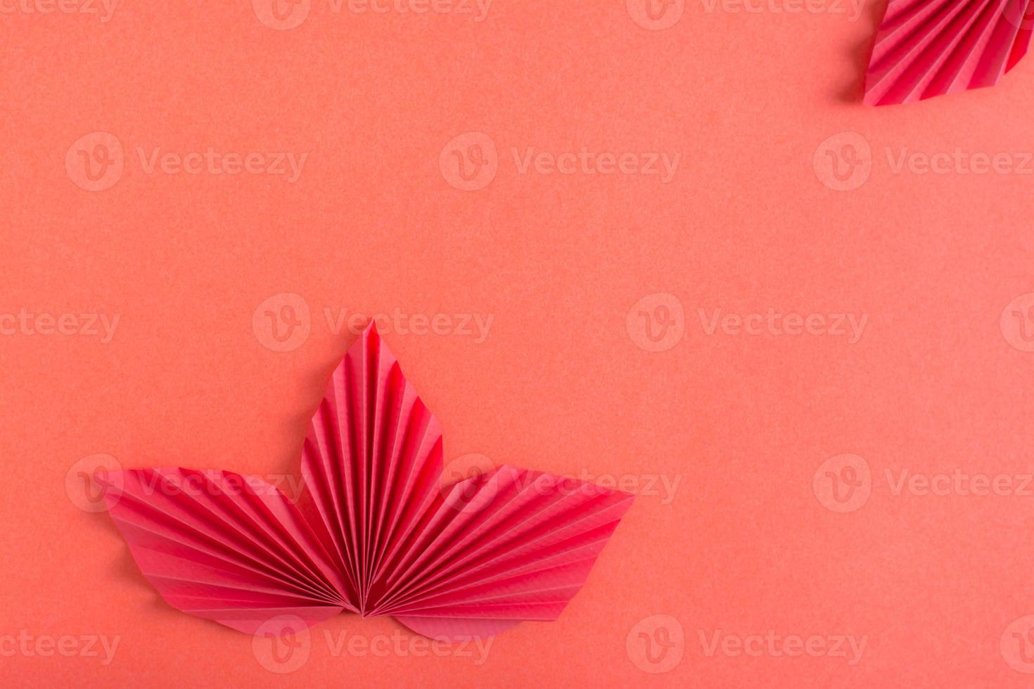 Red orgami leaves on a red background. Monochrome background. Copy space photo