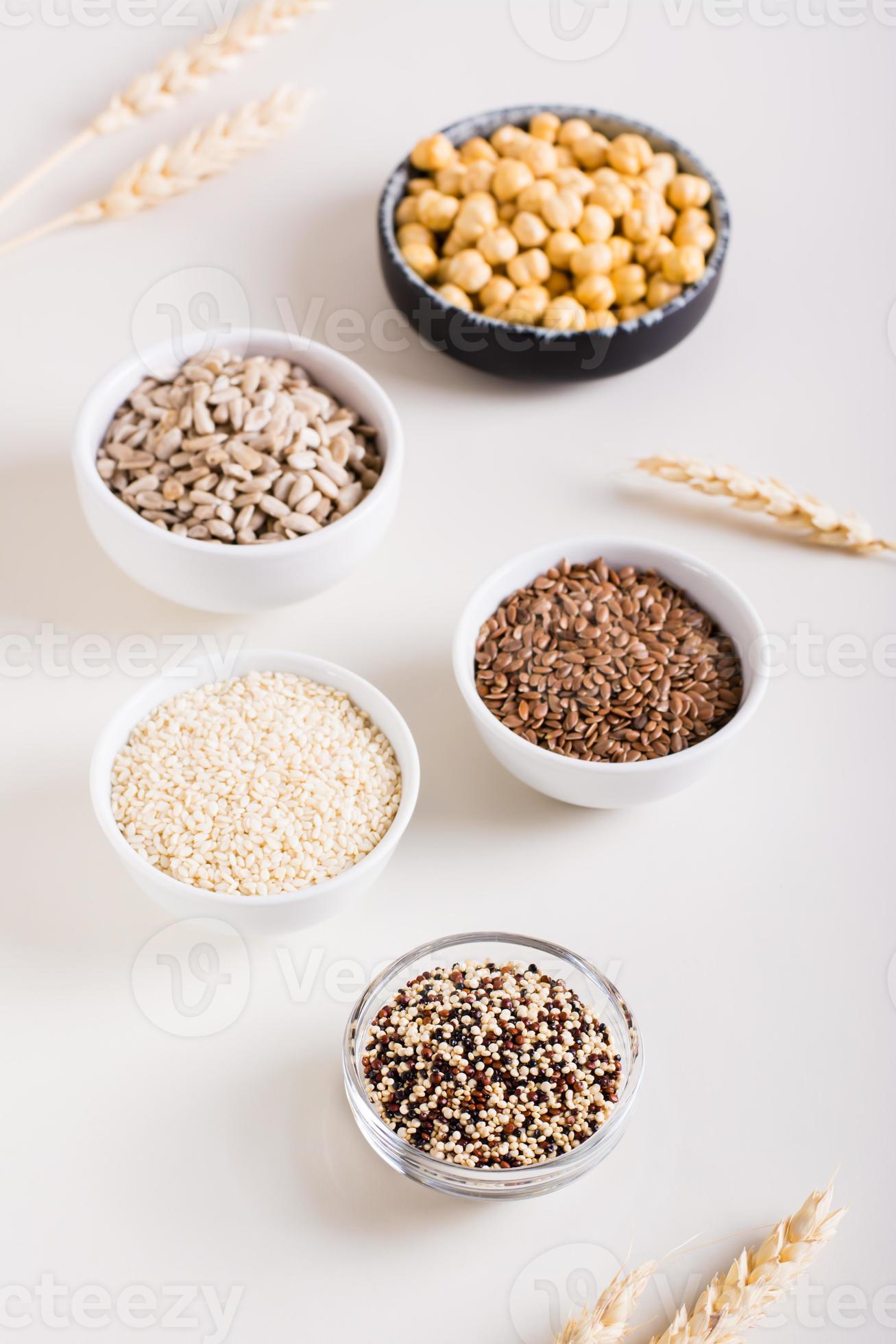 Quinoa, sesame, flax seeds, sunflower seeds and chickpeas in bowls on