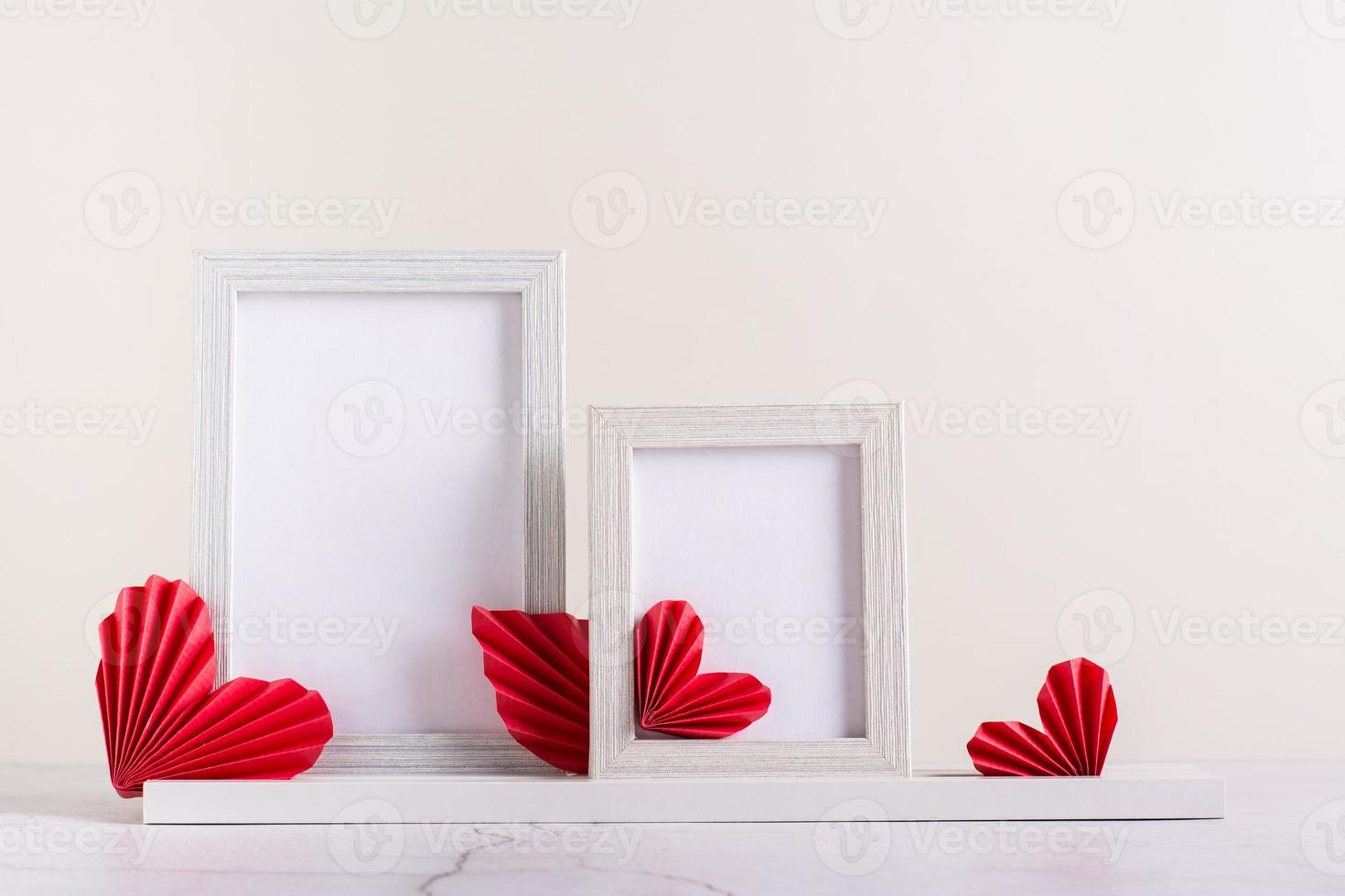 Two blank photo frames decorated with DIY paper hearts. Home decor.