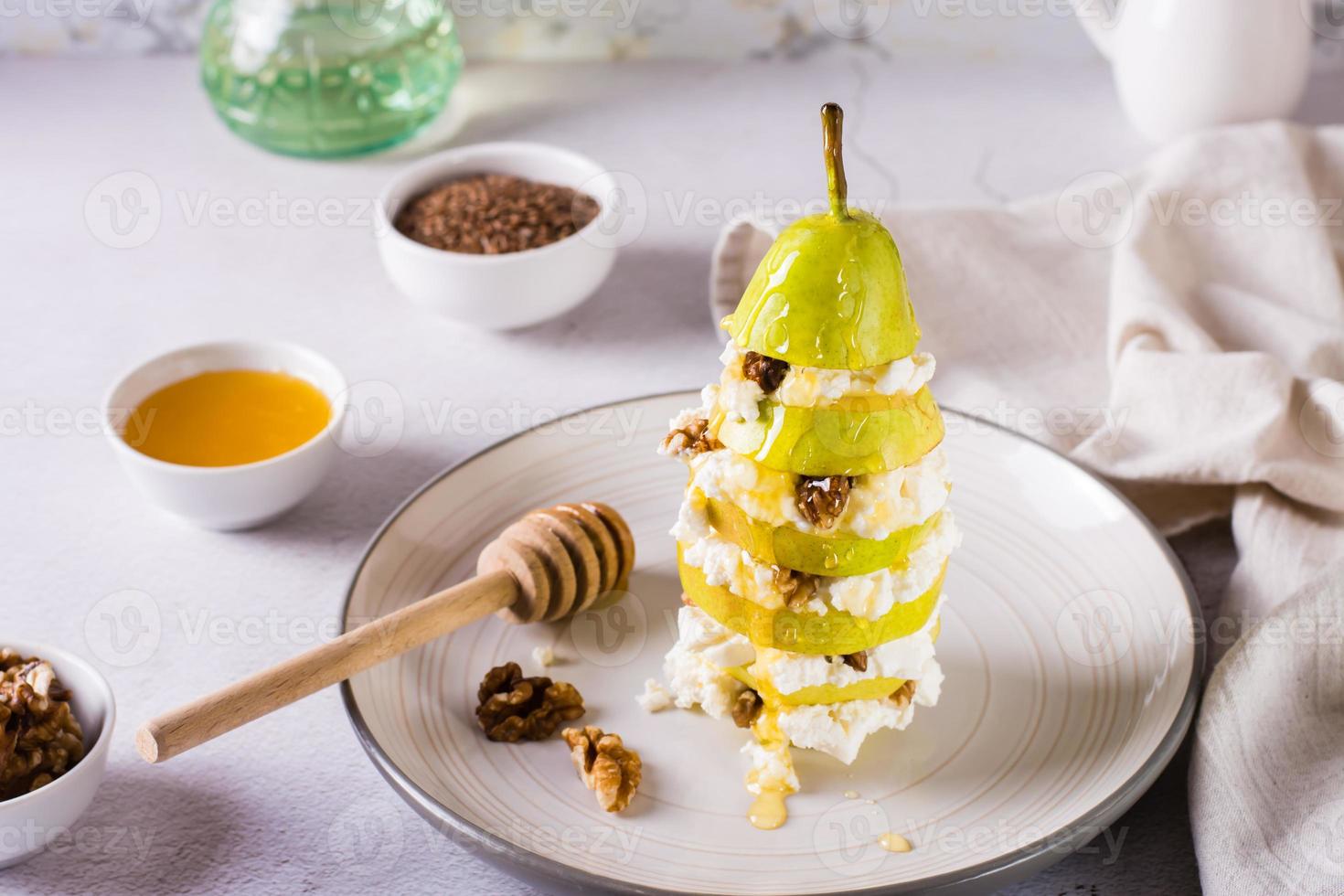 capas de pera, ricotta con nuez vertida con miel en un plato sobre la mesa. nutrición vitamínica. foto