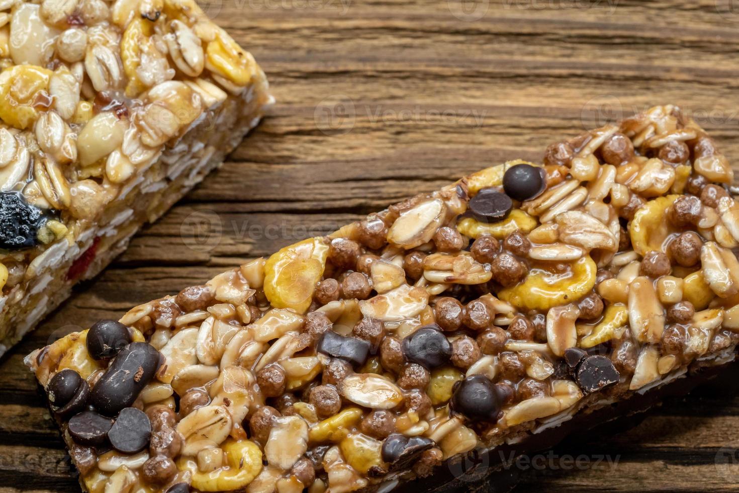 Cereal superfood energy bars with almond nuts, dry fruits, raisins chocolate on the wood table photo