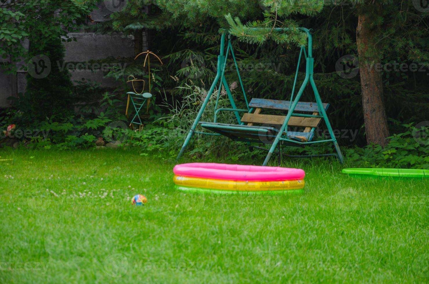 en los columpios de césped y piscina inflable foto