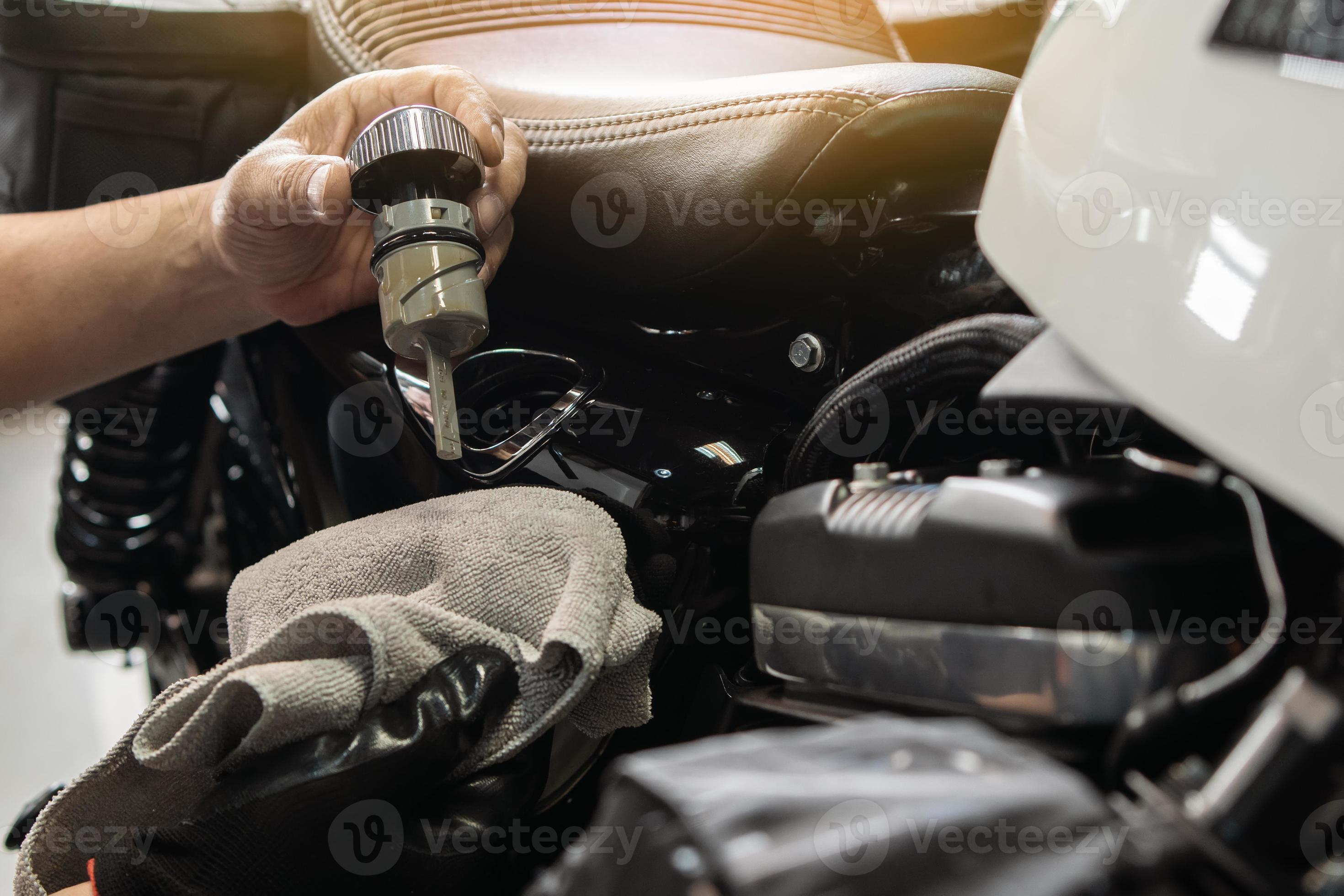 mechanic check engine oil level with oil dipstick on motorcycle or big