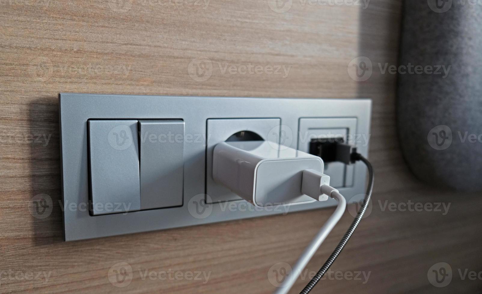 Electrical power socket, usb socket, light switch on the wood panel in the interior of the hotel. For convenience, the mobile charger or smartphone in the concept of modern life. Close up. photo