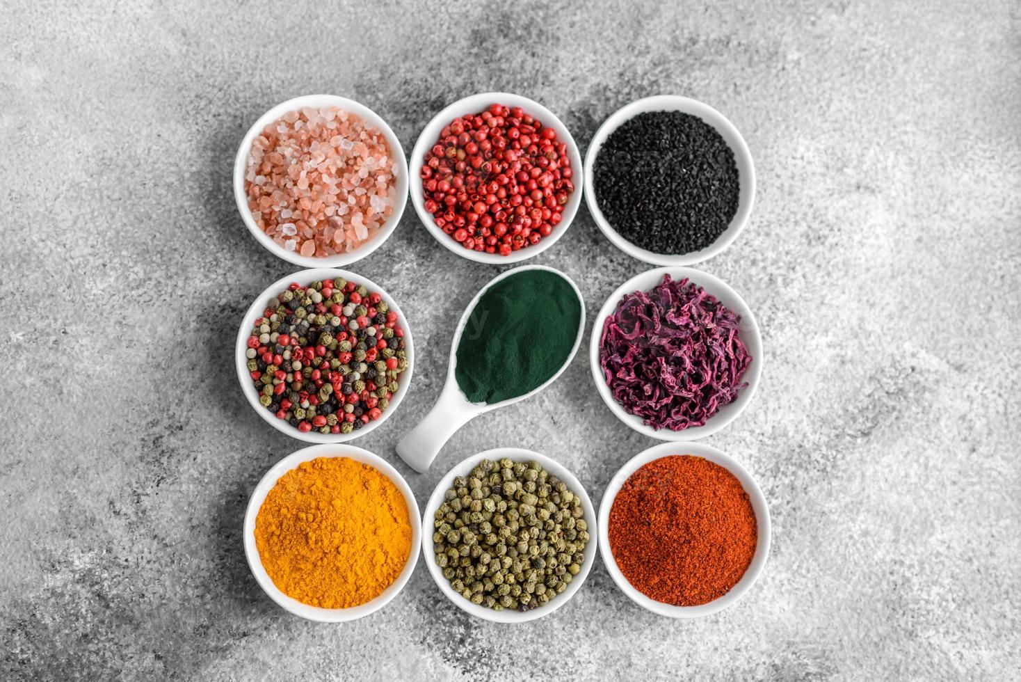 Composition consisting of a variation of several types of spices in white bowls photo