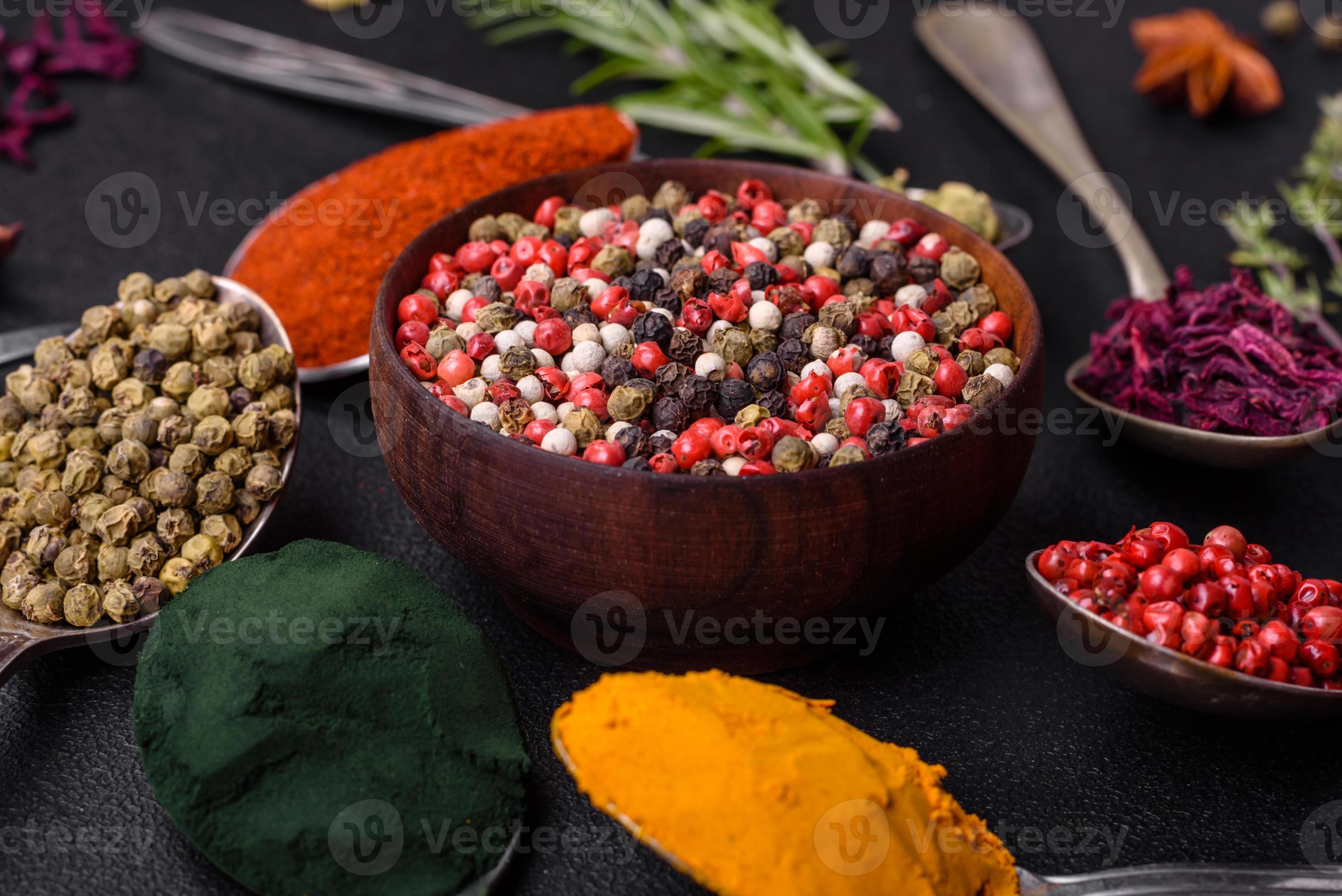 Variation of spices in metal spoons paprika, turmeric, cardamom, a ...