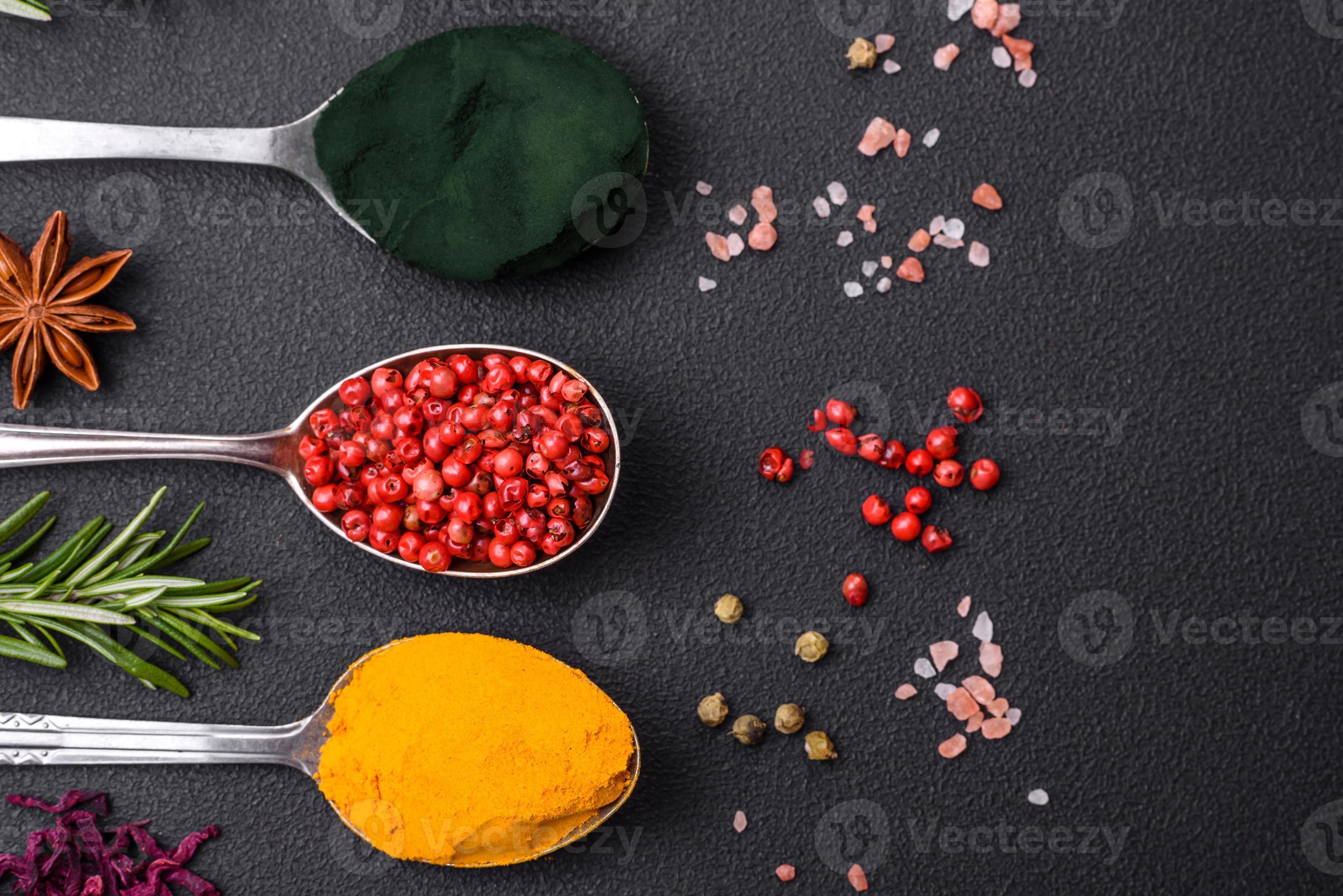 Variation of spices in metal spoons paprika, turmeric, cardamom, a ...