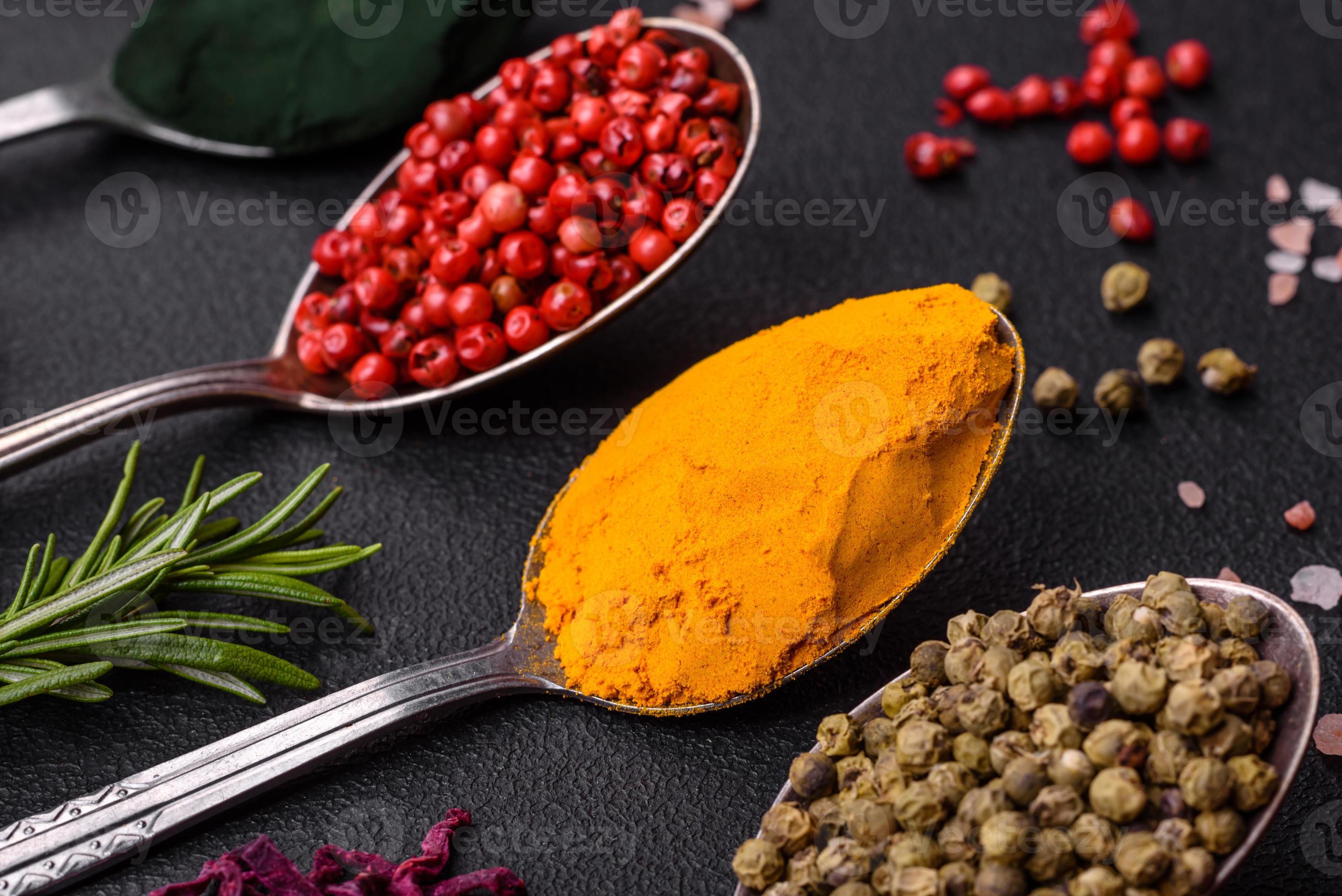 Variation of spices in metal spoons paprika, turmeric, cardamom, a
