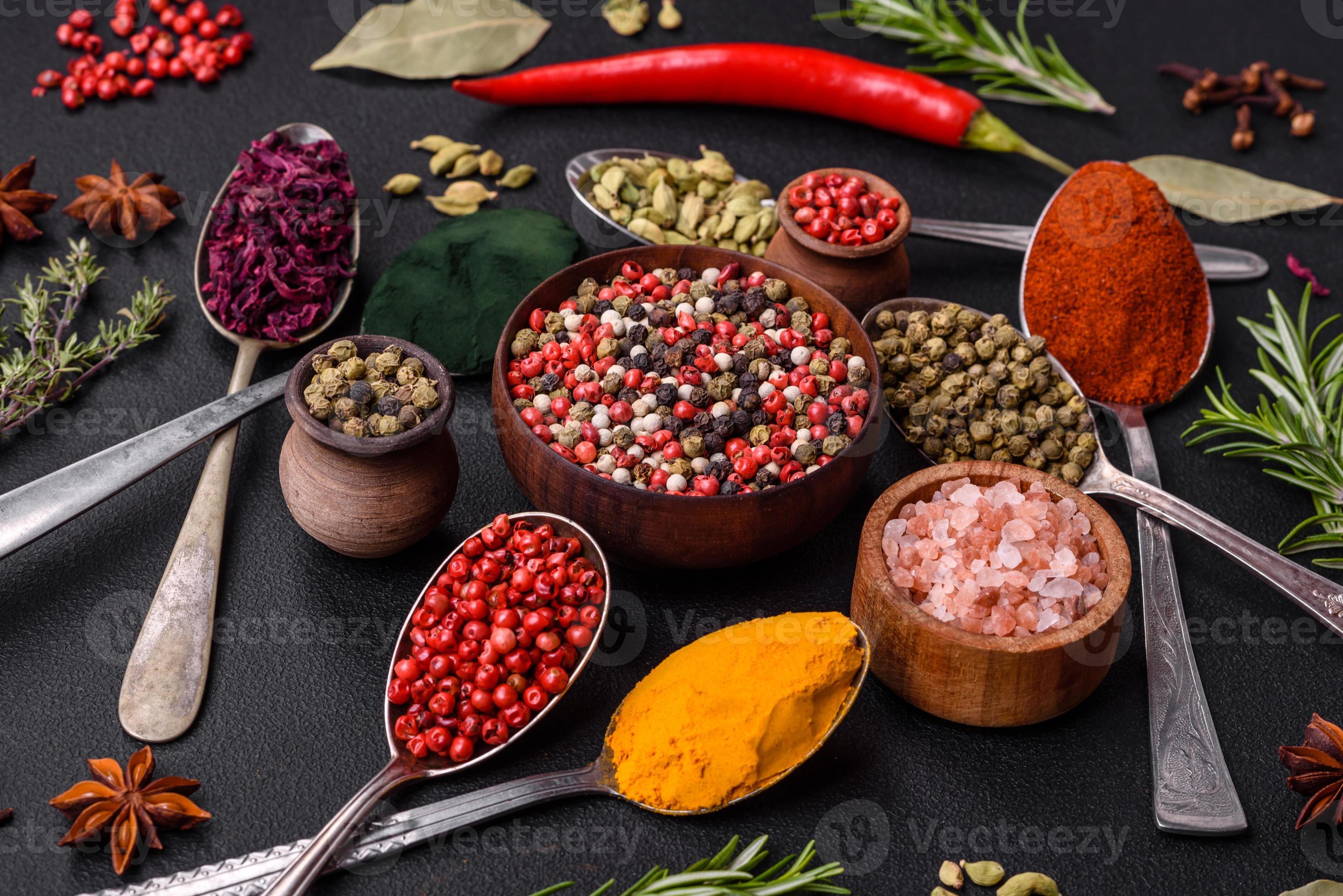 Variation of spices in metal spoons paprika, turmeric, cardamom, a ...