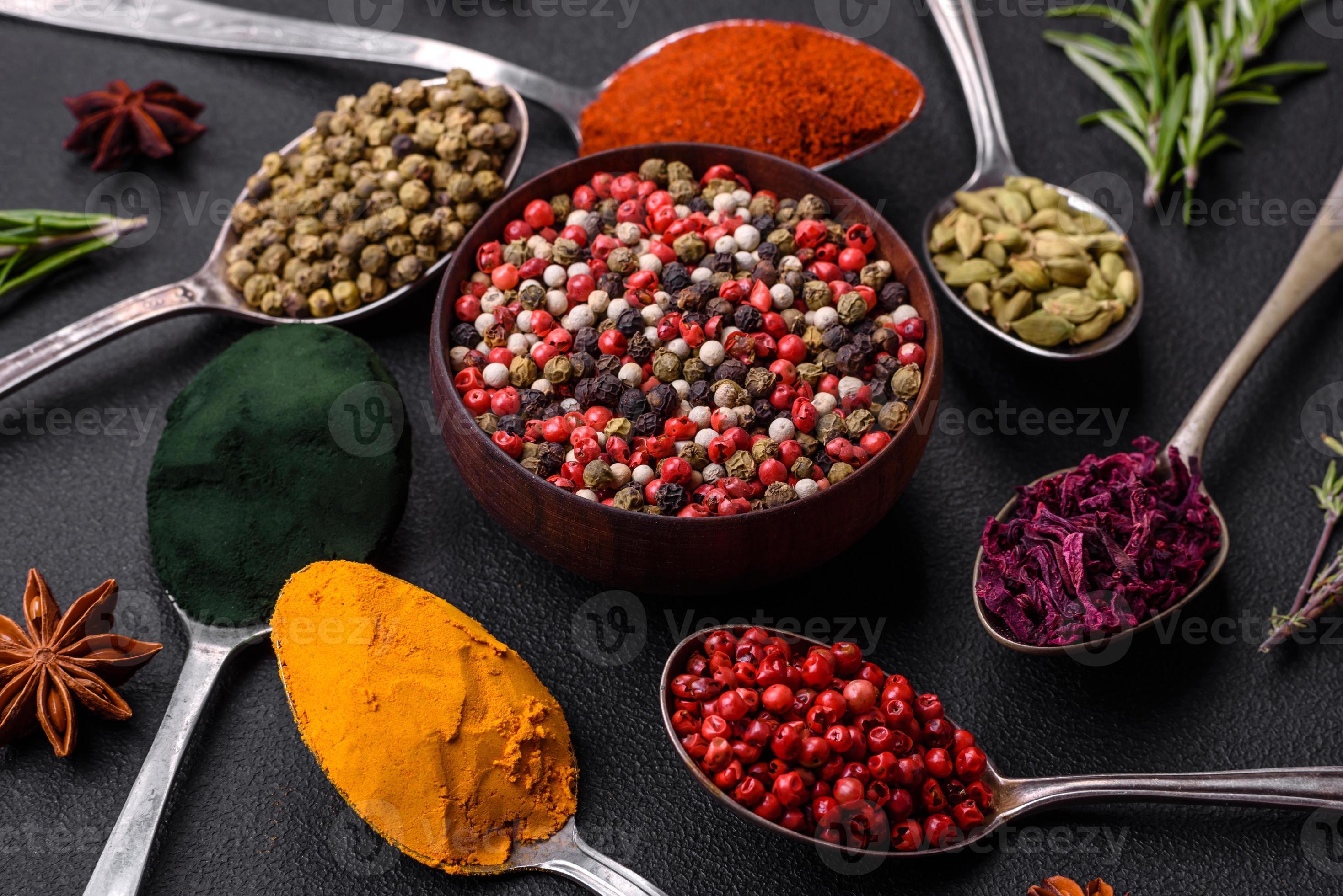 Variation of spices in metal spoons paprika, turmeric, cardamom, a ...