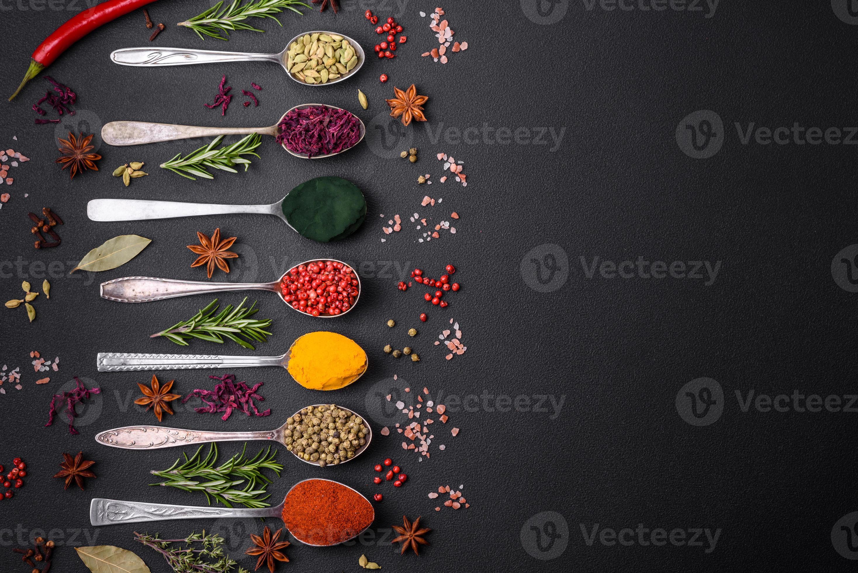 Variation of spices in metal spoons paprika, turmeric, cardamom, a ...