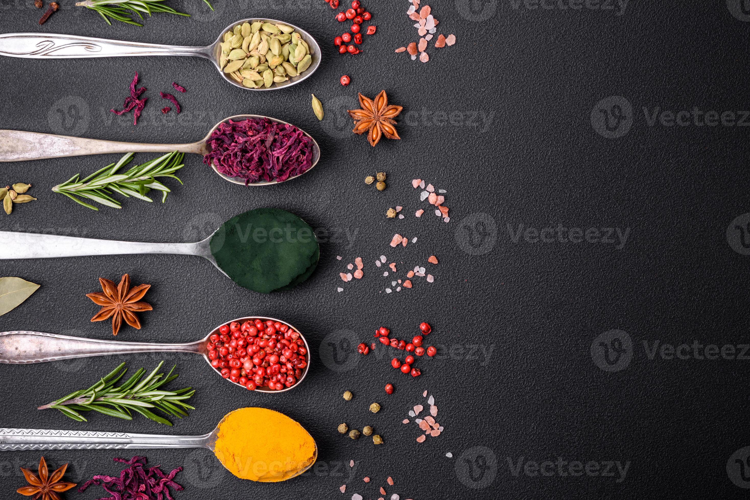 Variation of spices in metal spoons paprika, turmeric, cardamom, a ...