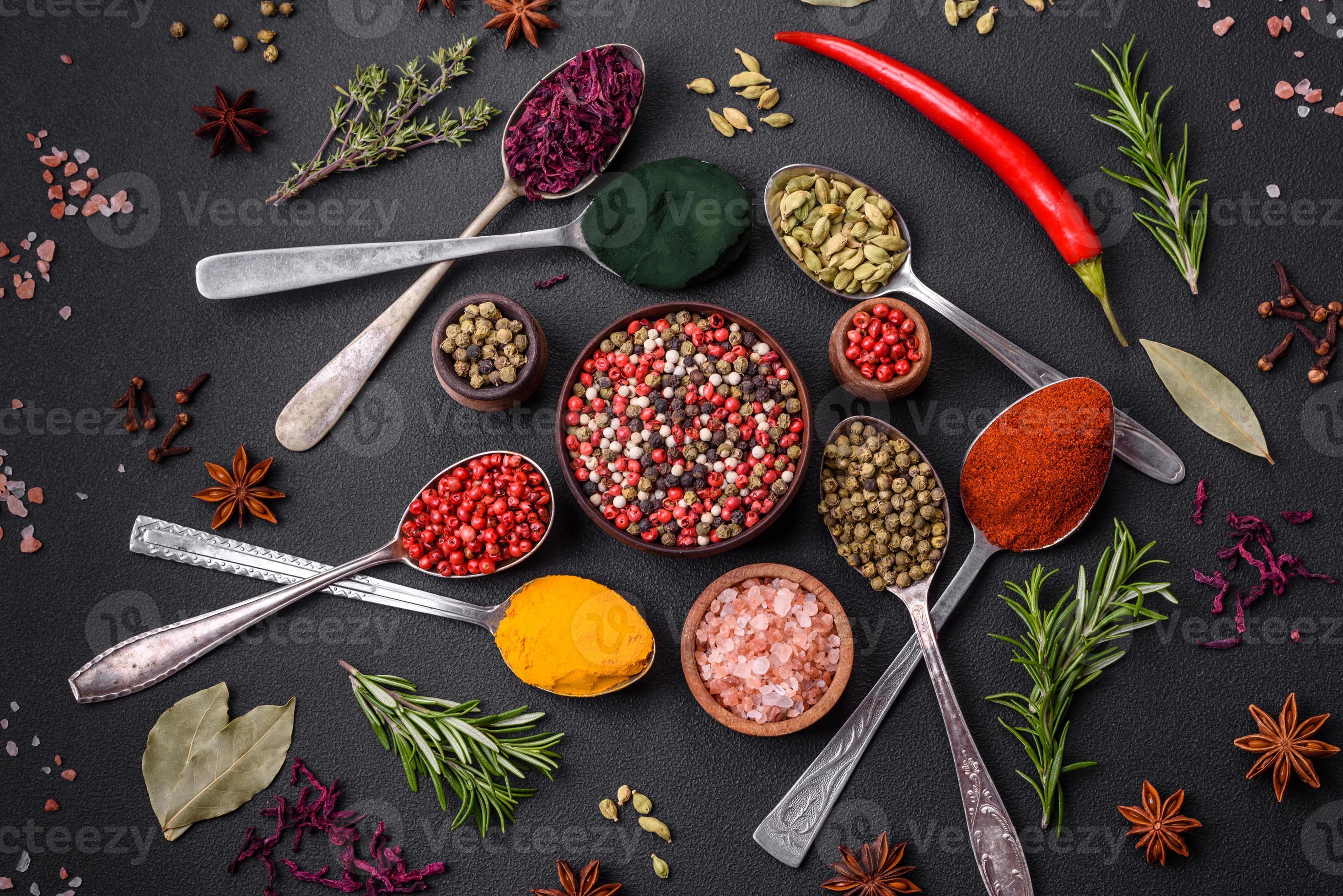 Variation of spices in metal spoons paprika, turmeric, cardamom, a ...