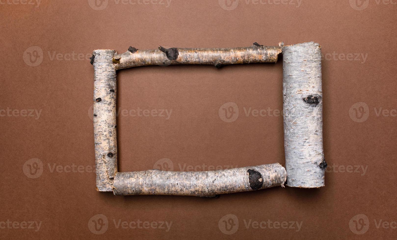 Bright natural brown background with frame of birch trunk parts and copy space for text inside it. photo