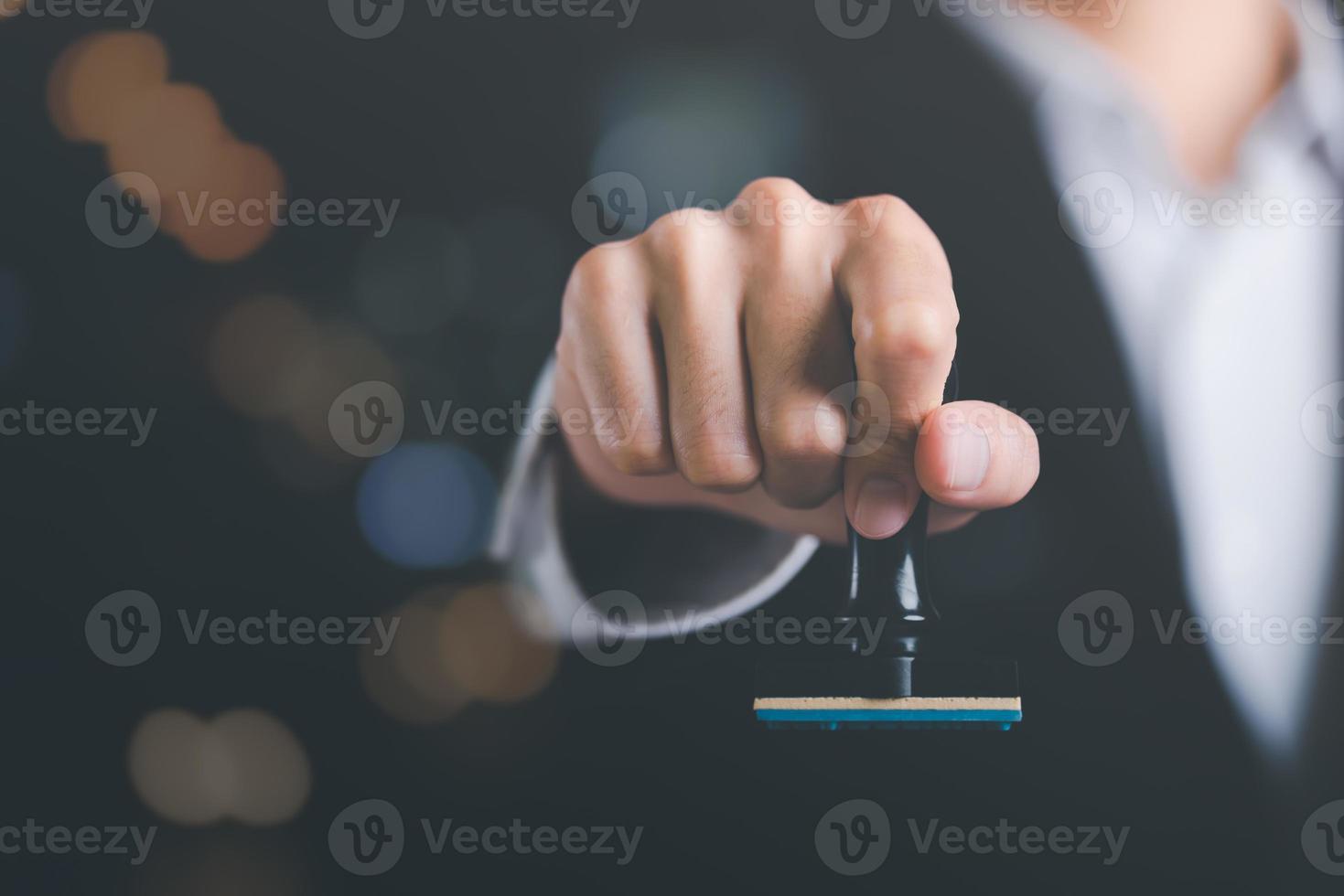 Businessman holding stamp in hand, confirming or approving agreement,Authority to approve applications for Bank loan documents,verification or acceptance process,legal document certification photo