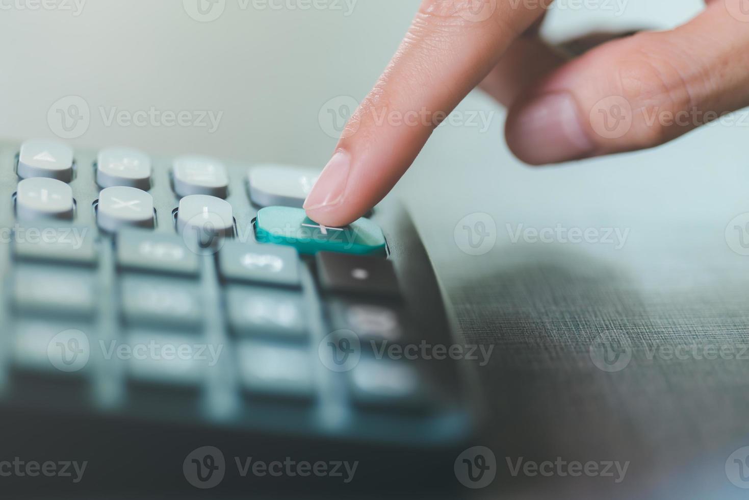 Businessman hand using a calculator,The concept of numerical calculations in company financial documents,analysis of company financial data,Planning to assess and review budgets photo