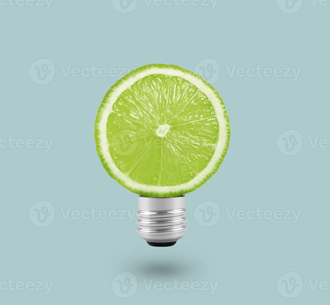 Green Lemon light bulb on bright blue background. Summer fun concept photo