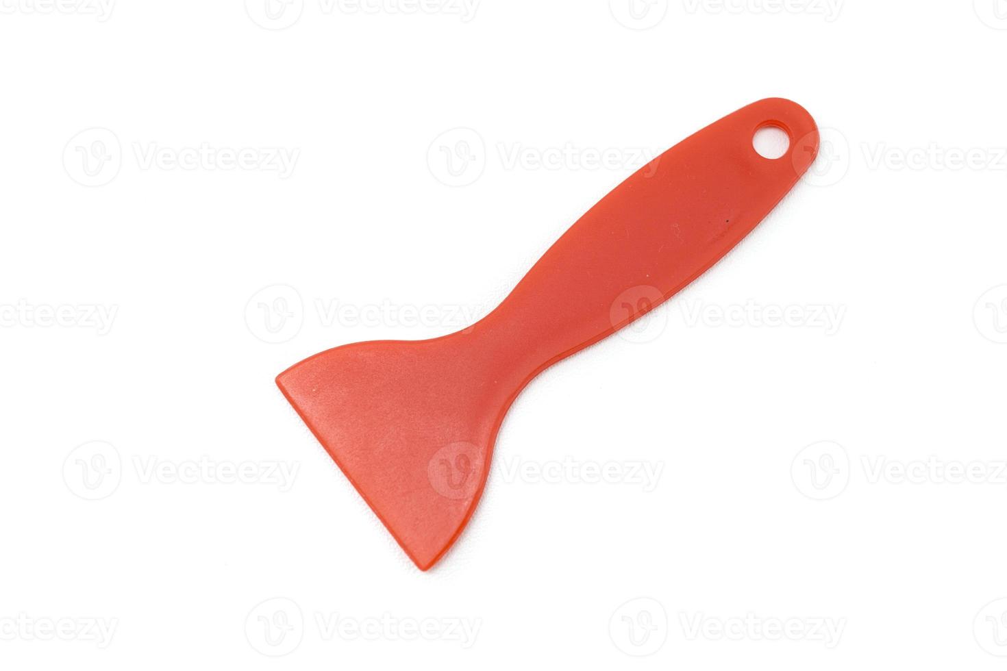 red plastic spatula raclette isolated on a white background photo