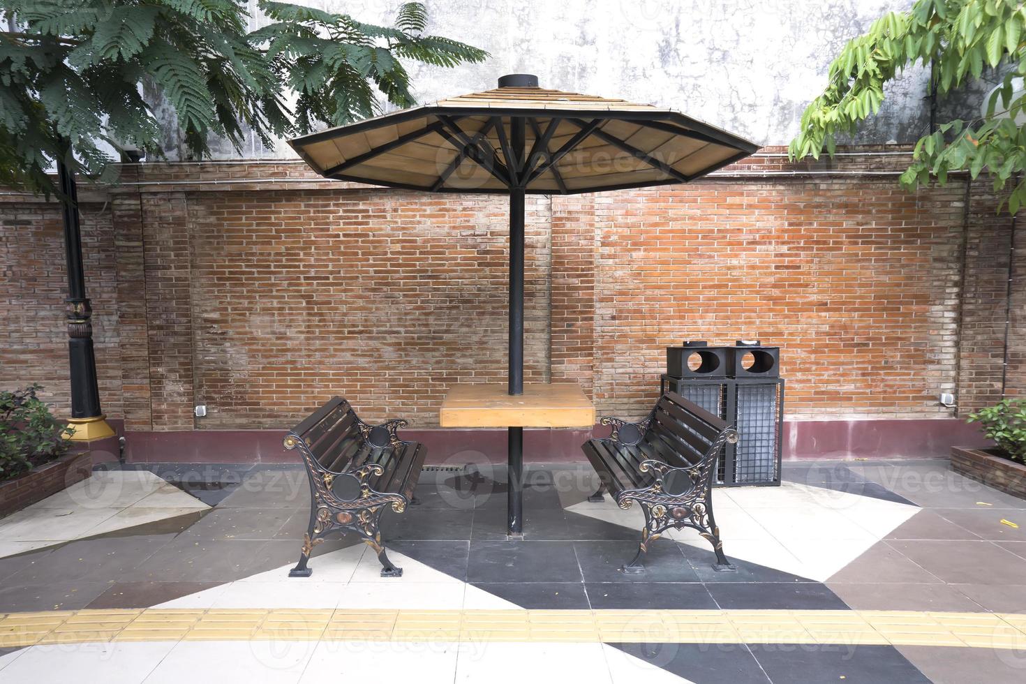 dining table with metal chairs and umbrella in city park photo