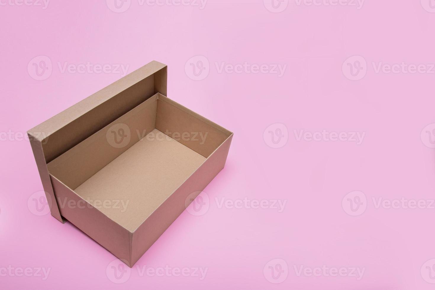 caja de artesanía abierta vacía sobre fondo rosa con espacio de copia foto