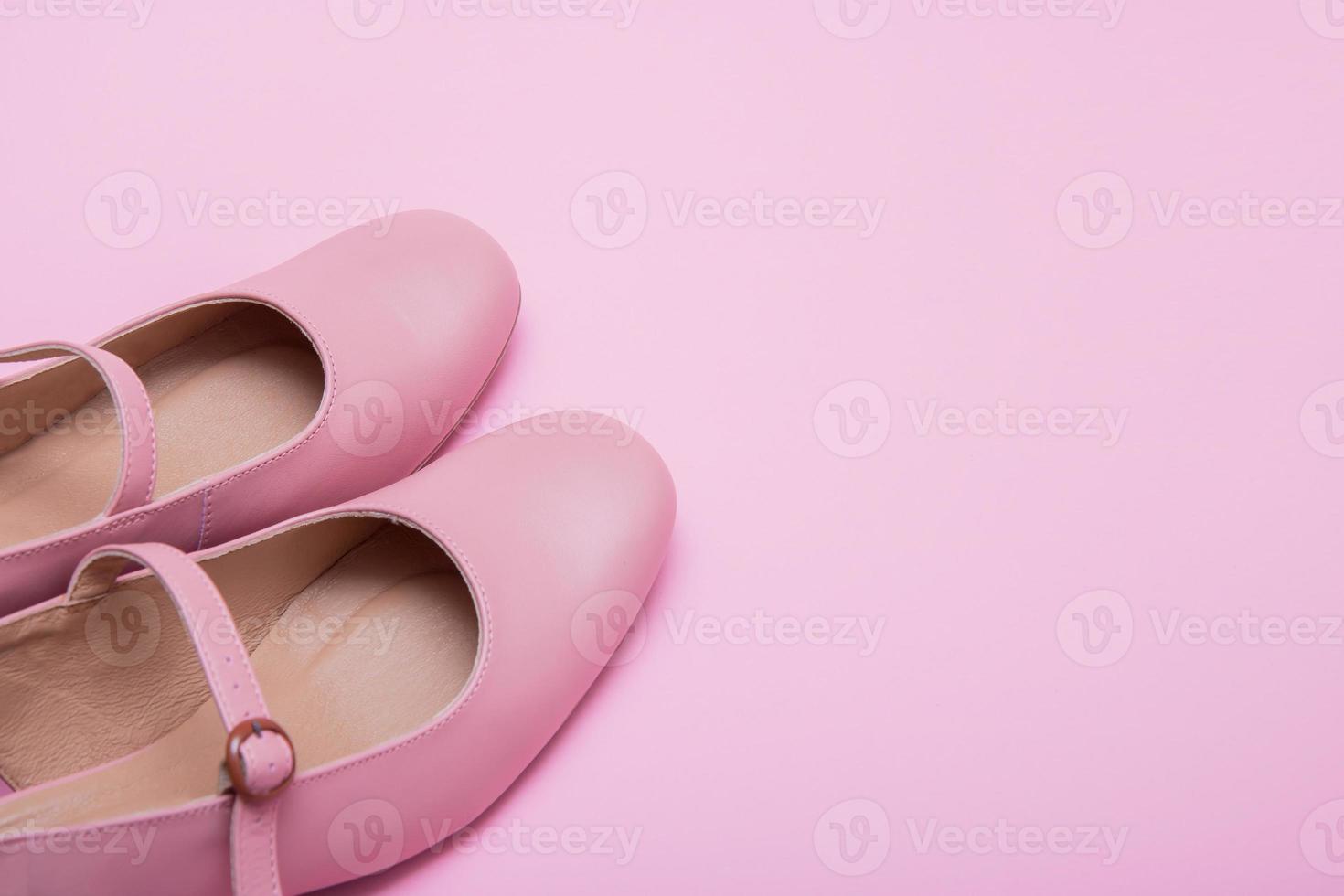 women's pink shoes with a clasp on a pink background with copy space photo