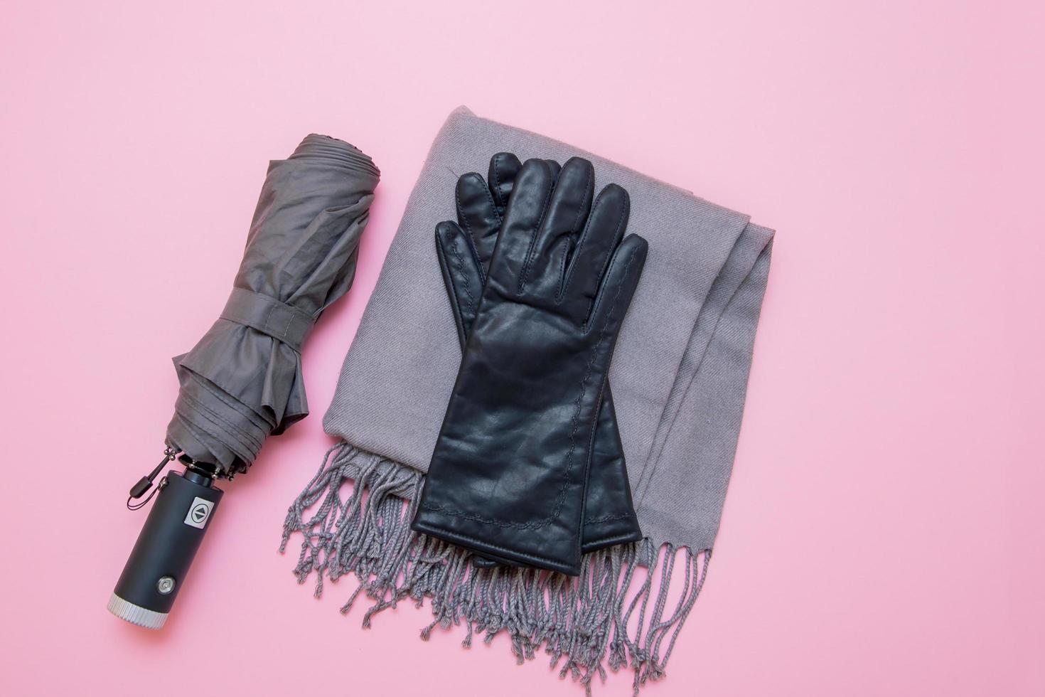 autumn accessories umbrella, gloves and tippet on pink background photo