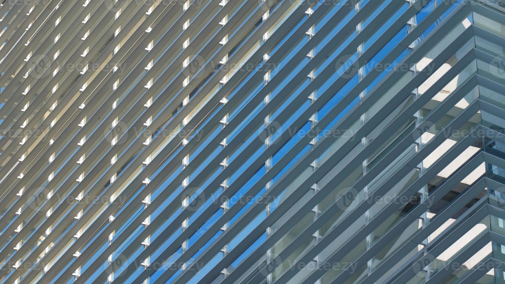 Approach to the glass windows reflecting a blue sky of a modern building. Abstract background photo