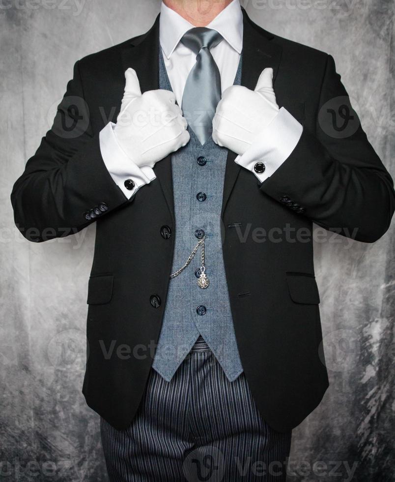Portrait of Elegant Butler or Concierge in Dark Gray Suit and White Gloves Standing Proudly. Concept of Service Industry and Professional Courtesy. photo