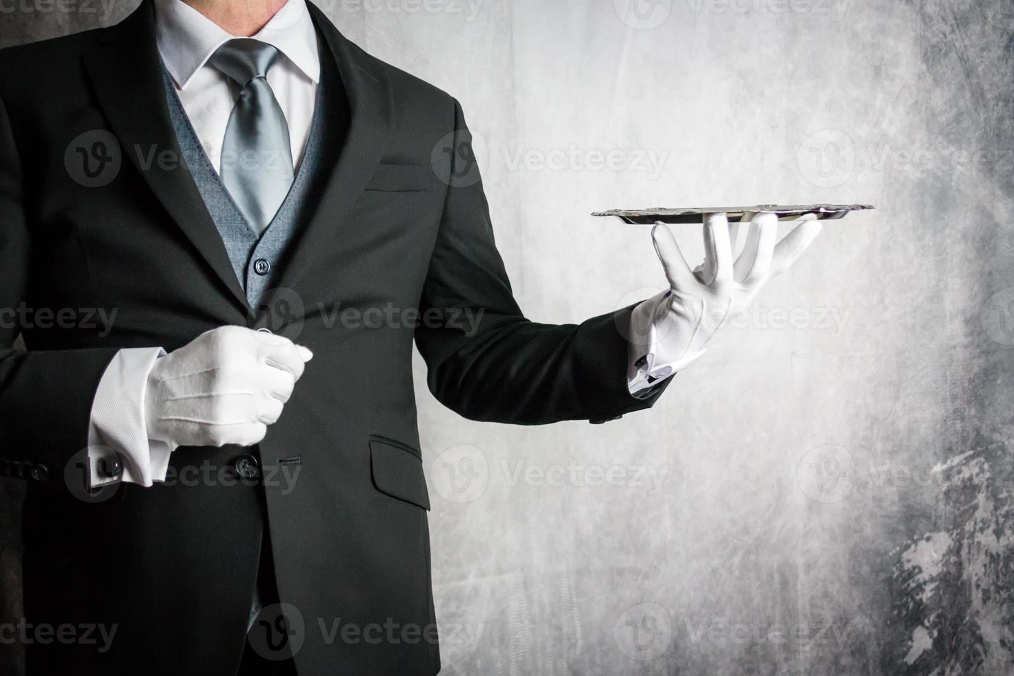Portrait of Butler or Waiter in Formal Attire Elegantly Holding Silver Serving Tray. Copy Space for Service Industry and Professional Hospitality. photo