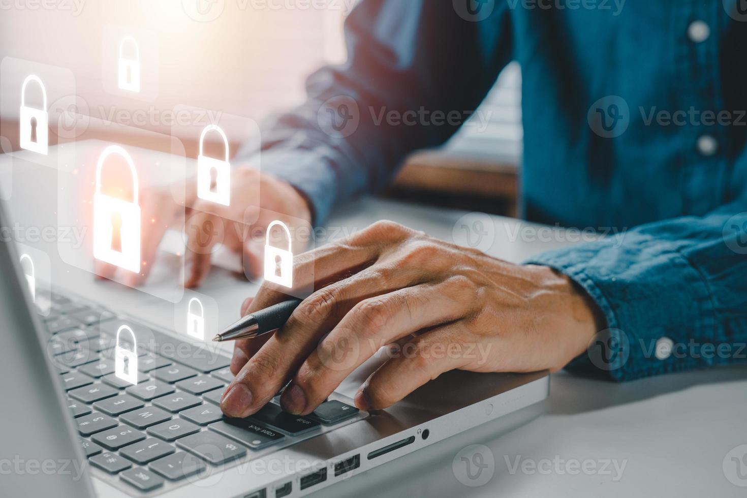 Cyber security concept, Businessman hand using computer with padlock security interface to protect data on desk, internet security. photo