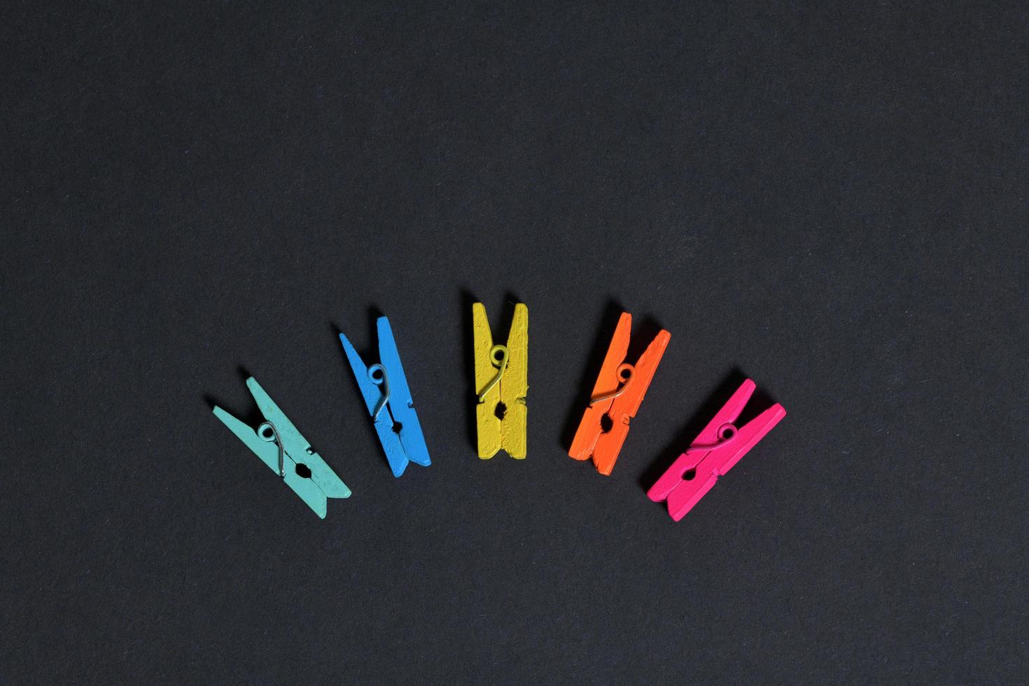 Colorful clothespins isolated on black background photo