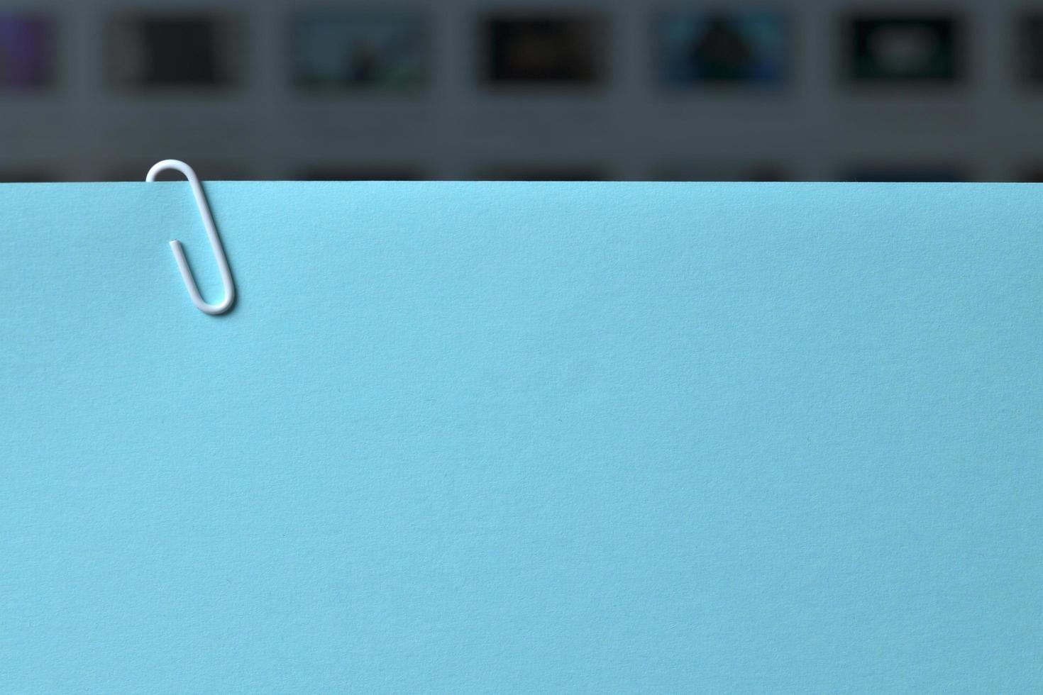Blue paper background with white paper clip. Computer display in