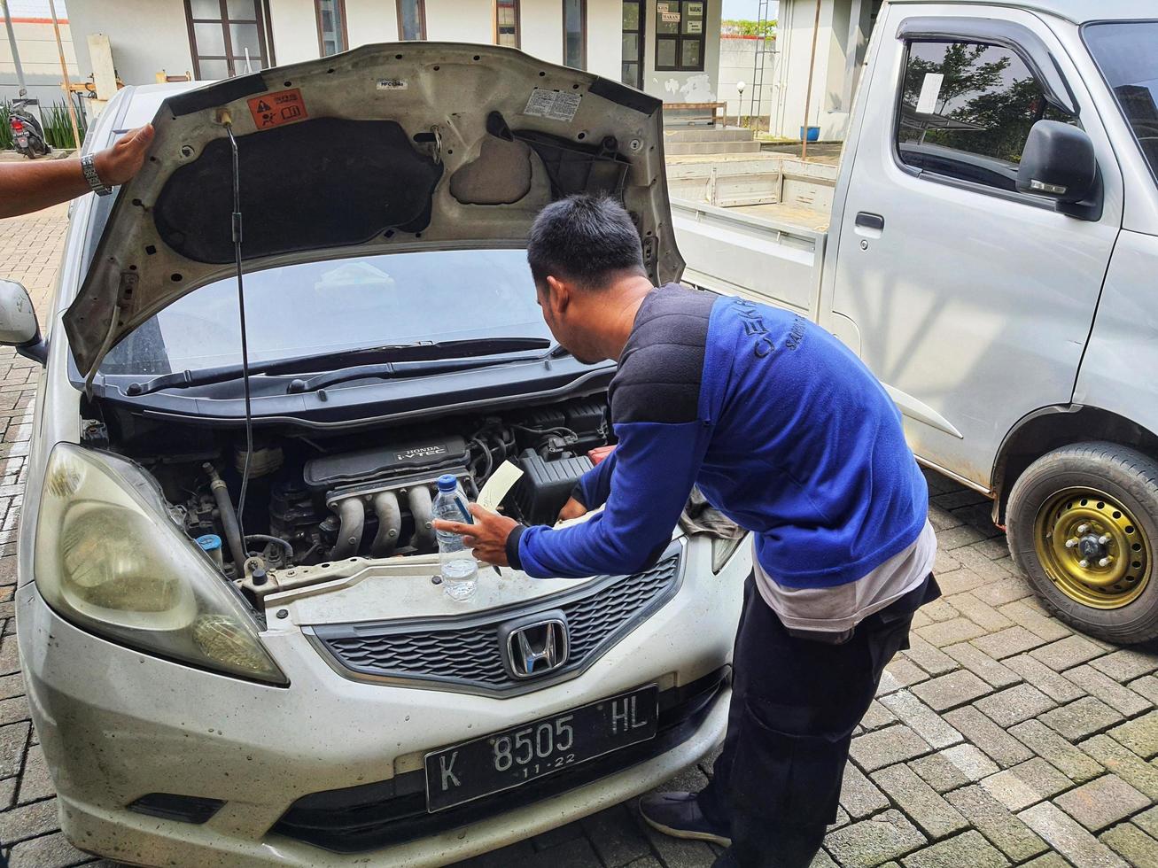 Central Java, Indonesia in October 2022. An officer is carrying out a physical check of a vehicle that will extend or replace its license plate number. photo