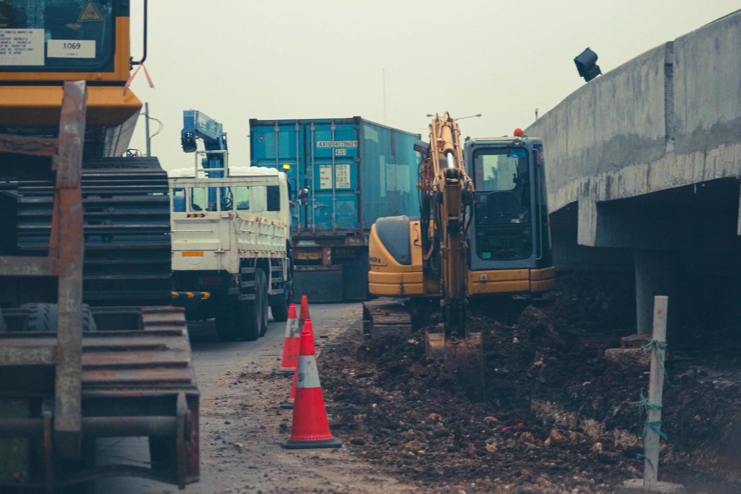 yakarta, indonesia en julio de 2022. una miniexcavadora está cavando un canal de drenaje en la carretera foto