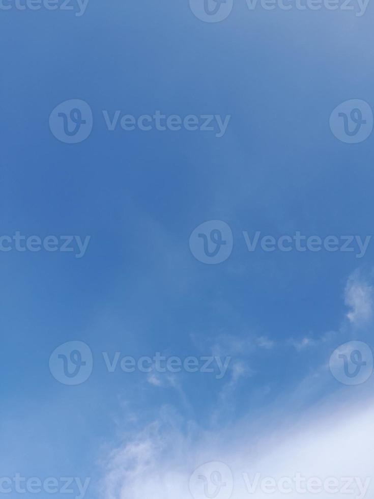 White clouds in the blue sky. Beautiful bright blue background. Light cloudy, good weather. Curly clouds on a sunny day. photo