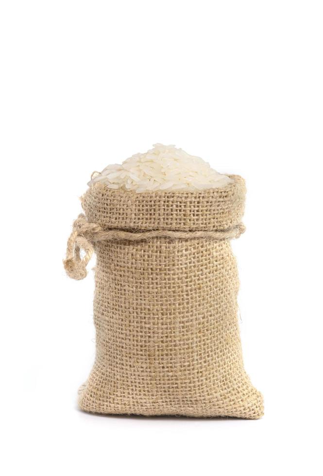 White organic raw jasmine rice in burlap sack bag isolated on white