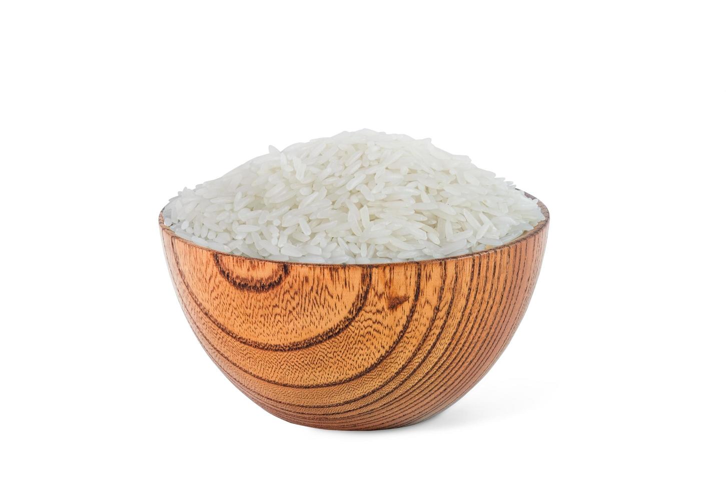 granos de arroz crudo en un tazón de bambú de madera marrón, sobre fondo blanco. vista superior, espacio de copia, producto de alta resolución. foto