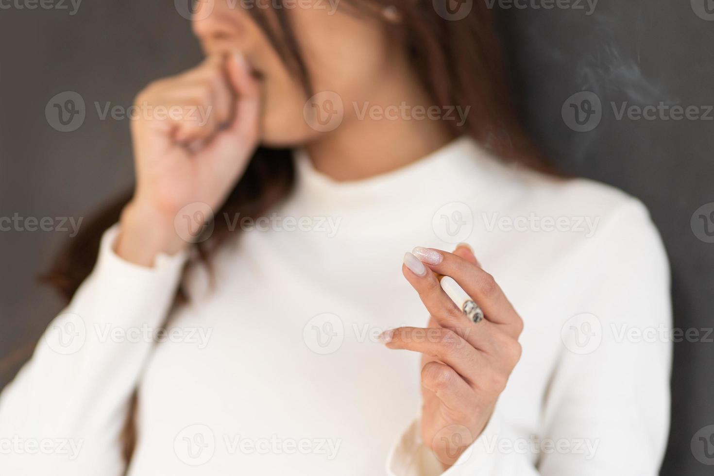 Closeup Asian woman coughing from smoking cigarette. photo